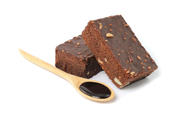 Chocolate brownie cake with Chocolate syrup in wooden spoon isolated on white background.