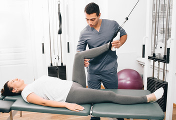 kinesiologist doing therapeutic exercises for a woman. Kinesitherapy at the medical center