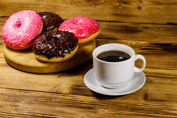Cup of coffee and tasty donuts on a wooden table