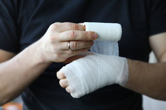 Male hand with tight elastic bandage on arm closeup
