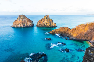 View of Morro dos Dois Irmãos and Baia dos Porcos in Fernando de Noronha, Brazil near sunset time.