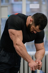 sport mind motivation concept of young strong muscle tired man with beard leaning in gym during workout pause