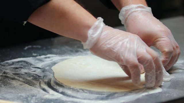 Kitchen - a man making a flat piece of dough