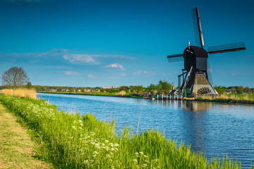 Old wooden windmill on the shore in Kinderdijk museum, Netherlands
