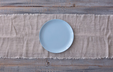 Cooking pancakes. Shrovetide (Maslenitsa) - blini stack on a blue plate on a wooden table.
