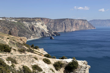 Fiolent. Top view on seacost of Crimea hillside in bright sunny day. Coast are rocky and stеeep slope. Sea are dark bright blue and rippled.