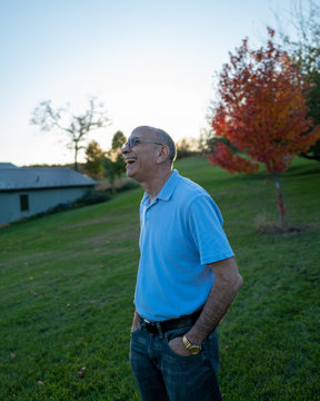 A man laughs in a backyard at a weekend vacation retreat in fall