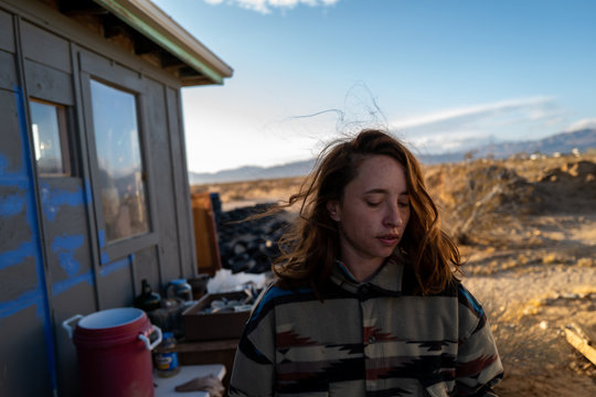 A woman's red hair in the windy off grid desert living in Joshua Tree, California
