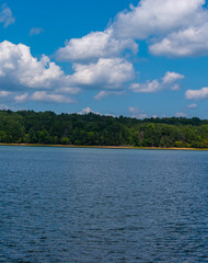 landscape with lake, white clouds and blue sky