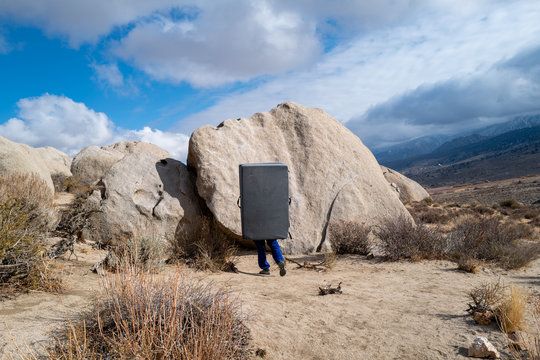 A climber carries a crash pad to a boulder problem in the Buttermilks near Bishop, CA
