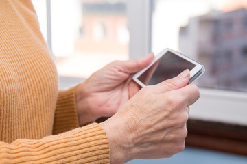 senior woman hands using mobile phone