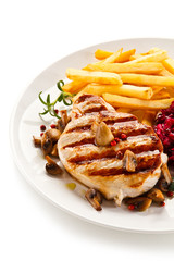 Grilled steak, French fries and vegetables on white background