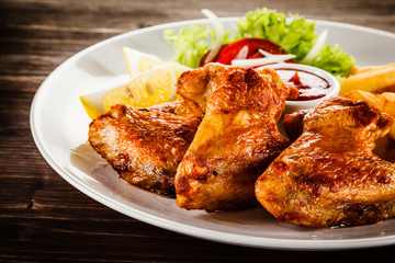 Fried chicken wings with french fries and vegetable salad