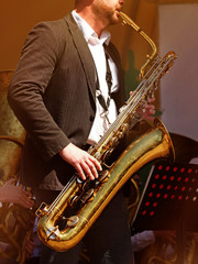 man in a suit playing a tenor saxophone