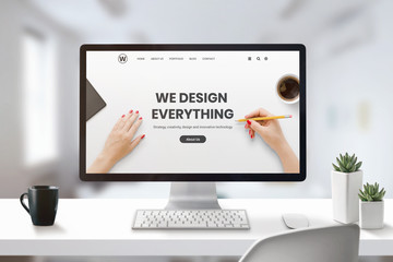 Web design studio concept with modern agency web page on computer display. Office, studio desk with...