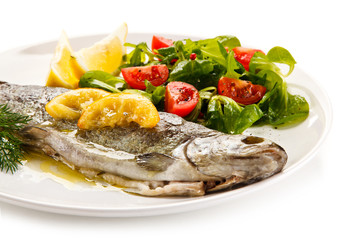 Fish dish - roasted trout with vegetables on white background