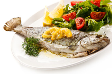 Fish dish - roasted trout with vegetables on white background