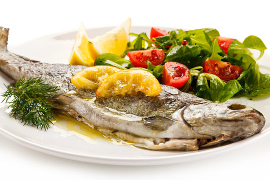 Fish dish - roasted trout with vegetables on white background