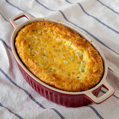 Homemade Cheese Corn Pudding Casserole on cloth, low angle view. Close-up.
