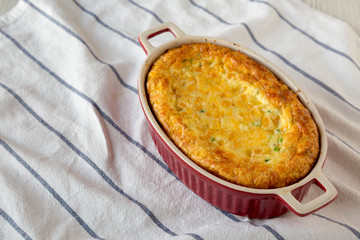 Homemade Cheese Corn Pudding Casserole on cloth, low angle view. Copy space.