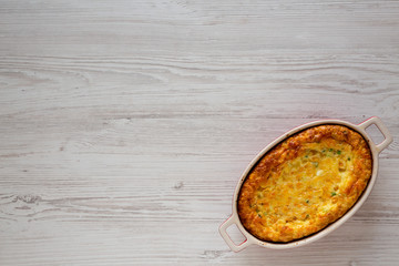 Homemade Cheese Corn Pudding Casserole on a white wooden background, top view. Flat lay, overhead, from above. Copy space.