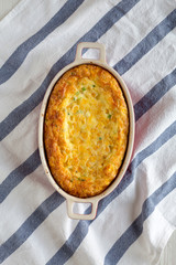 Homemade Cheddar Corn Pudding Casserole on cloth, view from above. Flat lay, top view, overhead.