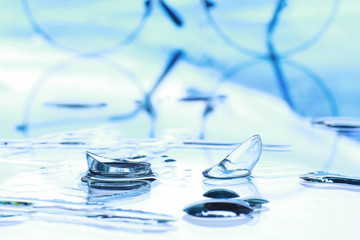 Tools for vision correction. Glasses and lenses with diopters on the background of splashes and...