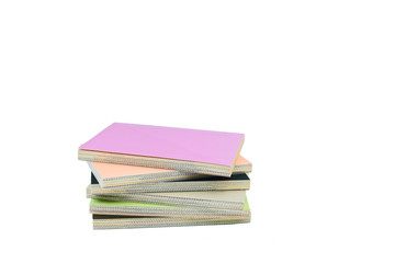 Notebooks, stacked over one another in front of a white background