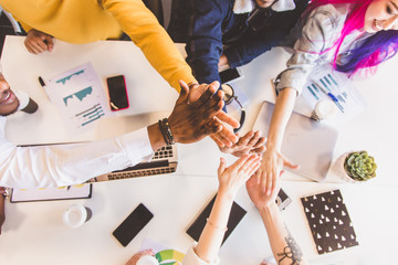 Group of multi ethnic executives discussing during a meeting. Business man and woman sitting around table at office and smiling. A team of young creative designers