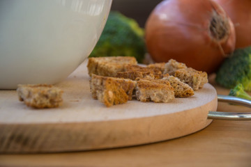 Close-up of healthy vegetarian food, vegetables - green broccoli, bread and onions in the kitchen placed on wooden table