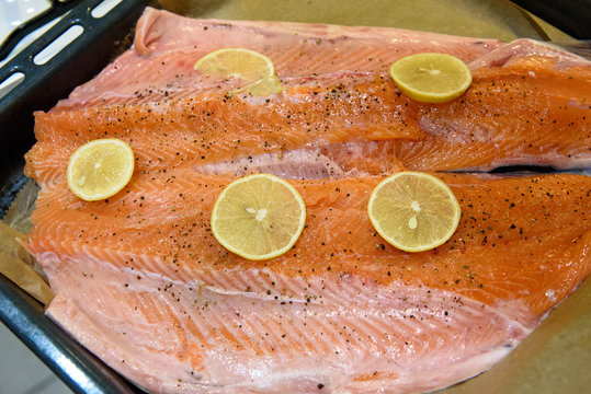Salmon fish with black peppers and lemon prepared for cooking.