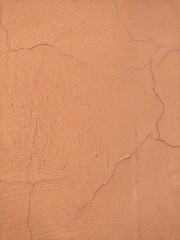 Peach-colored beige plaster with cracks