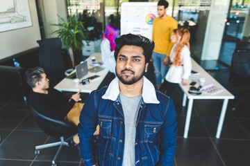 Group of multi ethnic executives discussing during a meeting. Business man and woman sitting around table at office and smiling. A team of young creative designers