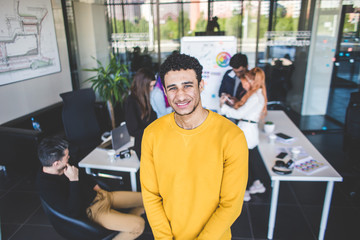 Fototapeta premium Group of multi ethnic executives discussing during a meeting. Business man and woman sitting around table at office and smiling. A team of young creative designers