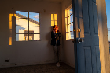 A red haired woman stands in an abandoned building in a desert ghost town