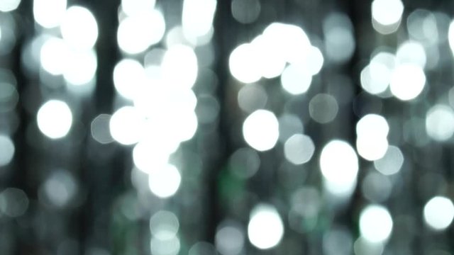 Abstract shiny background with silver defocused bokeh. Beautiful dynamic background in shining lights and sparkling particles. Festive mood. Christmas or holiday theme