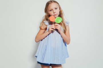 little girl eating sweet candy lollipop on a stick