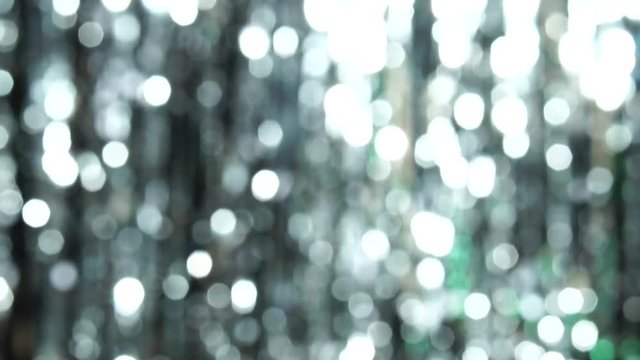 Abstract shiny background with silver defocused bokeh. Beautiful dynamic background in shining lights and sparkling particles. Festive mood. Christmas or holiday theme