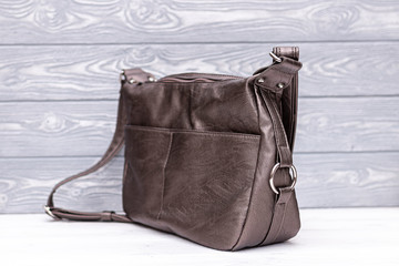 Fashion synthetic leather bronze handbag on a wooden background. Eco leather.