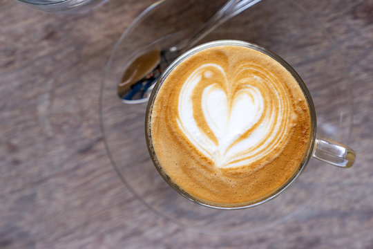 top view hot milk coffee with latter art heart shape in clear cup