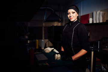 woman chef prepares fresh sushi in the kitchen of the restaurant