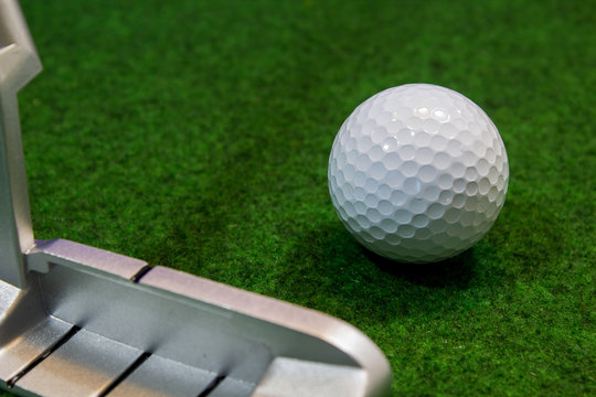 Putter, golf ball and green for the relaxed office life