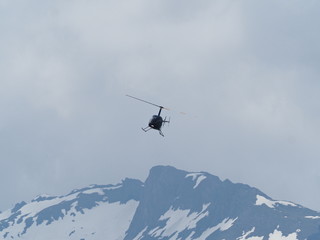 Fototapeta na wymiar Helikopter über Bergspitze