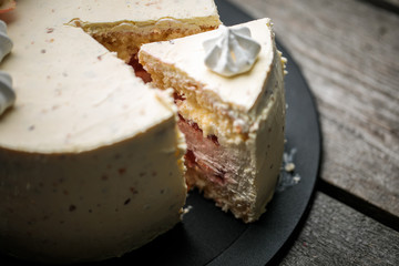 Сut sponge cake piece with strawberry cheesecake and meringue