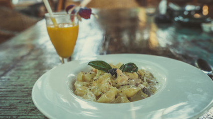 Pasta with white sauce with seafood, on a white plate with Cutlery