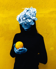 Female hand holding orange. Portrait Of Young Girl standing on color  background