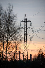 Selective focus photo. Beautiful view to powerful and huge high-voltage electricity poles, during sunset.