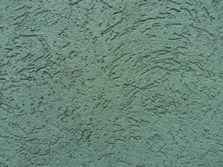 Plastered green wall. The finishing layer is formed by hardened mortar. The cement texture is...