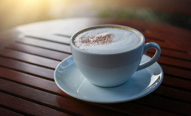 Blurred images of ready-to-drink cappuccino cups placed on a wooden table in the morning as background images and beautiful illustrations