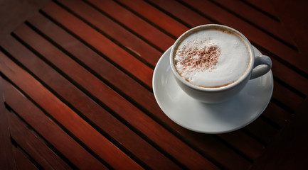 Blurred images of ready-to-drink cappuccino cups placed on a wooden table in the morning as background images and beautiful illustrations